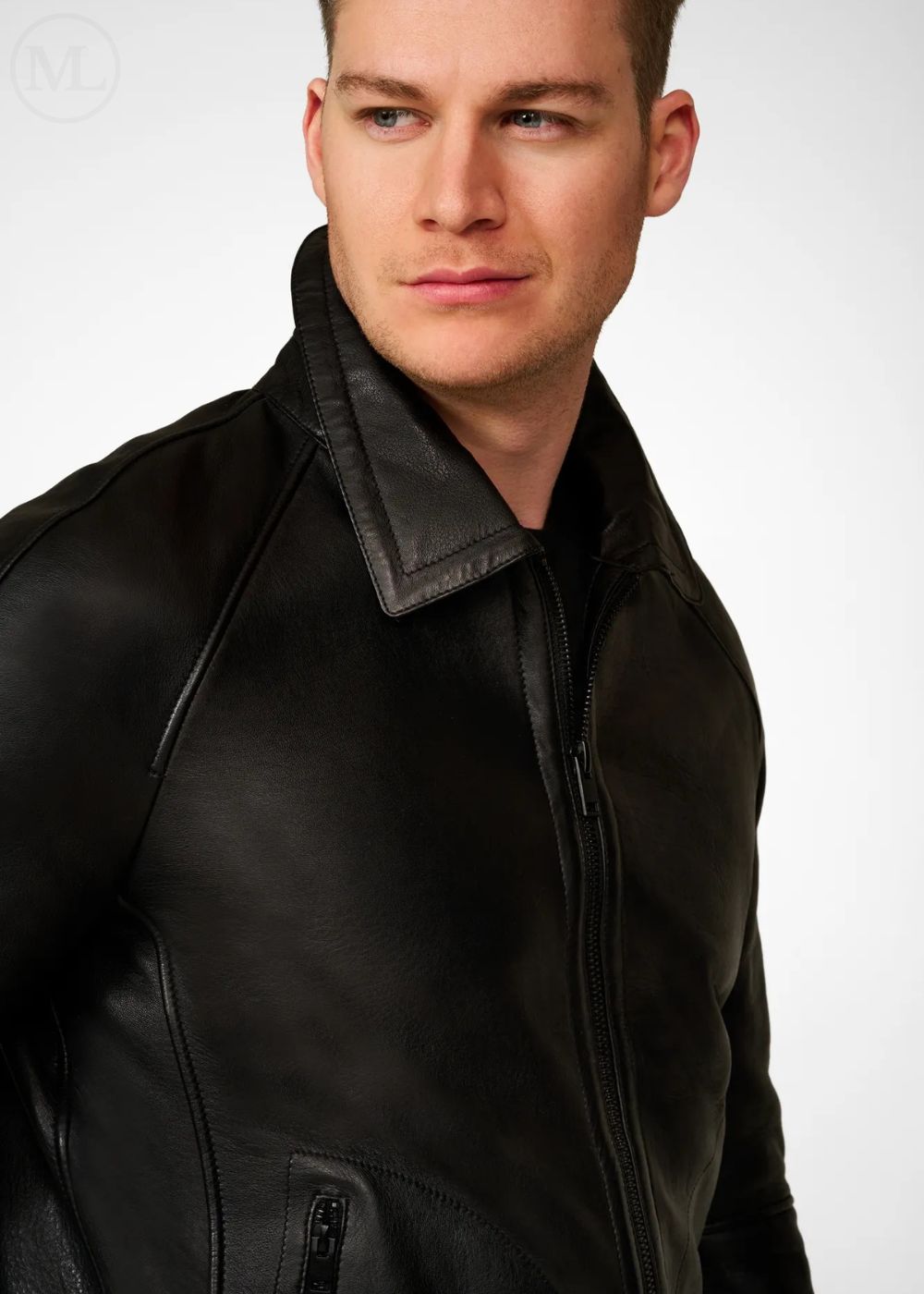 Man wearing a black leather bomber jacket against a white background