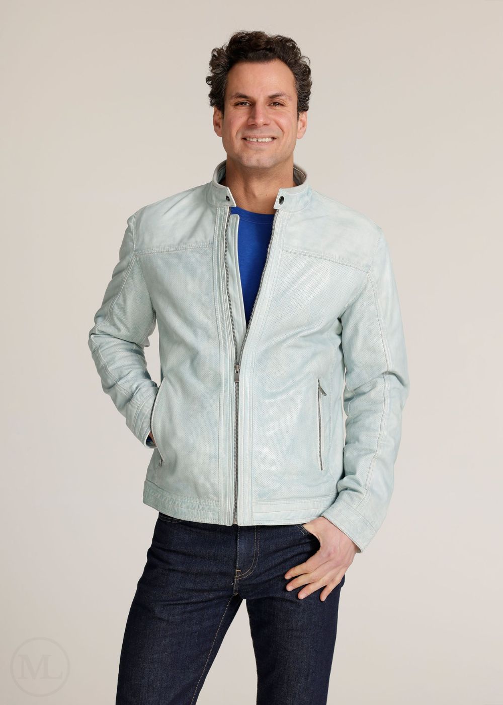 Man wearing a light grey jacket over a blue shirt on a beige background