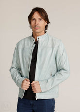 Man wearing a light grey jacket over a black shirt on a beige background