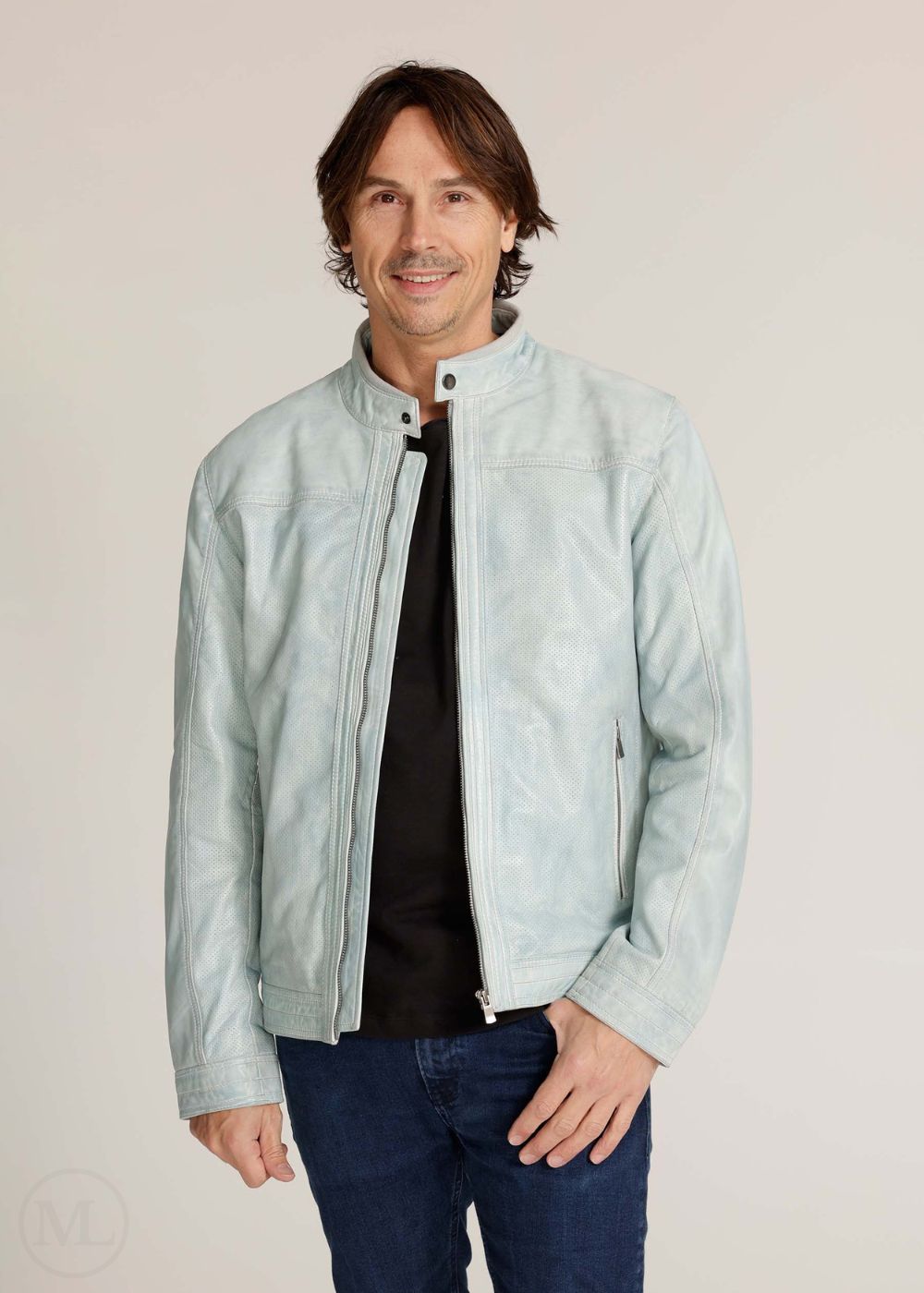 Man wearing a light grey jacket over a black shirt on a plain background