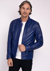Man wearing a navy leather jacket over a white shirt on a white background