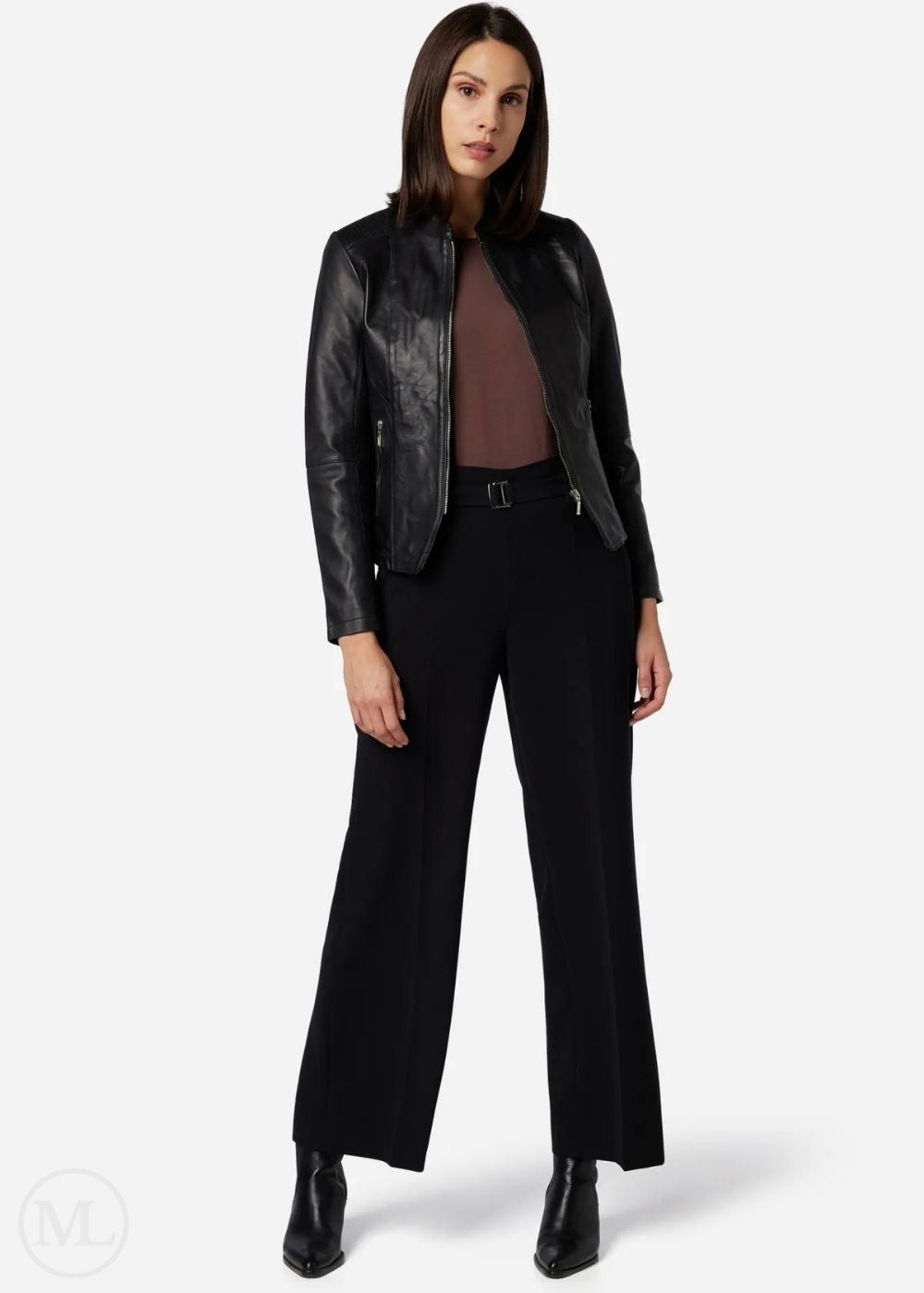 Woman wearing a black leather jacket and black pants on a white background