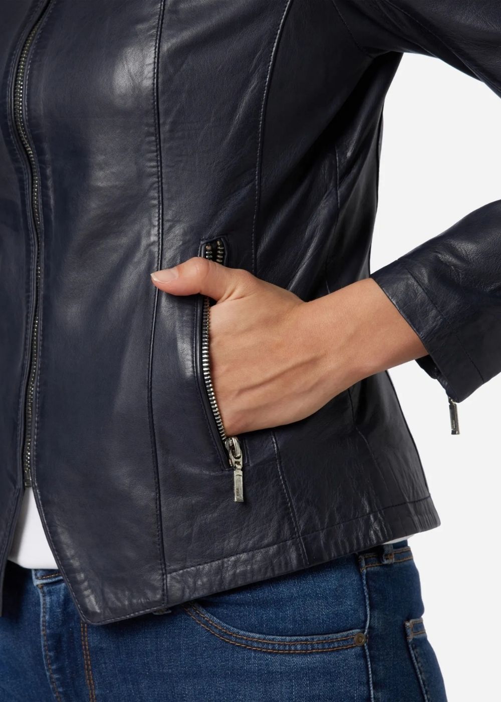 Woman wearing a blue leather jacket with a hand on the zipper.