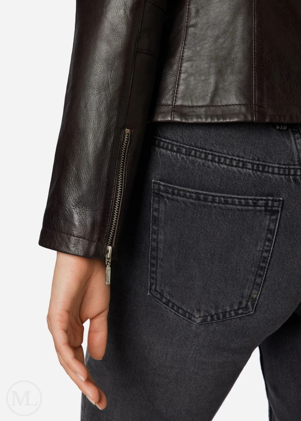 Close-up of a woman wearing a brown leather jacket and dark jeans on a white background