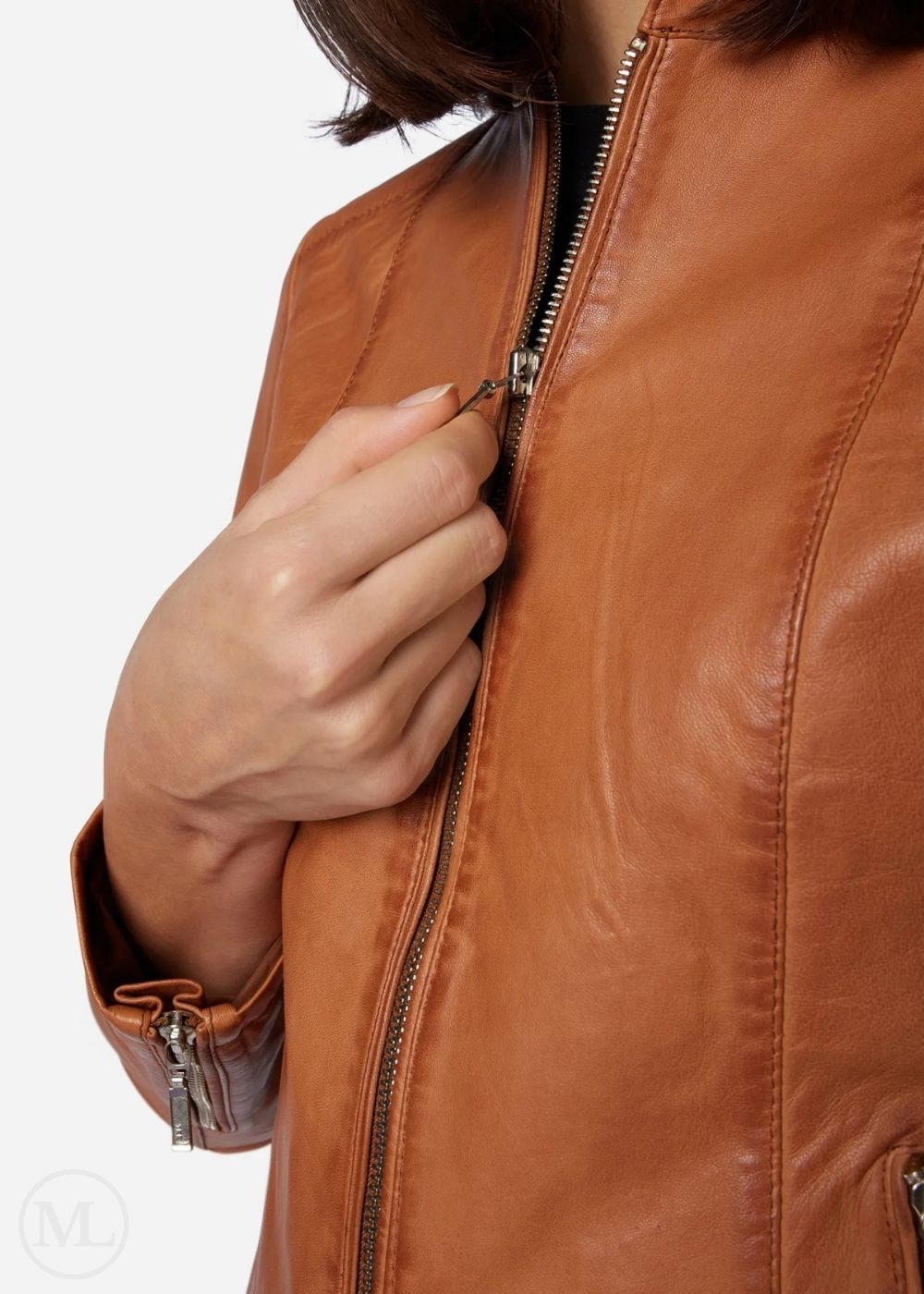 Close-up of a woman wearing a cognac brown leather jacket with a zipper.