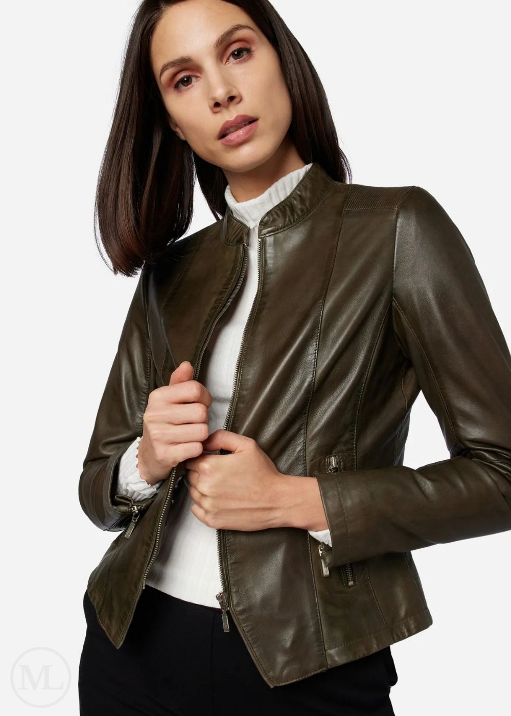 Woman wearing a olive green leather jacket on a plain background