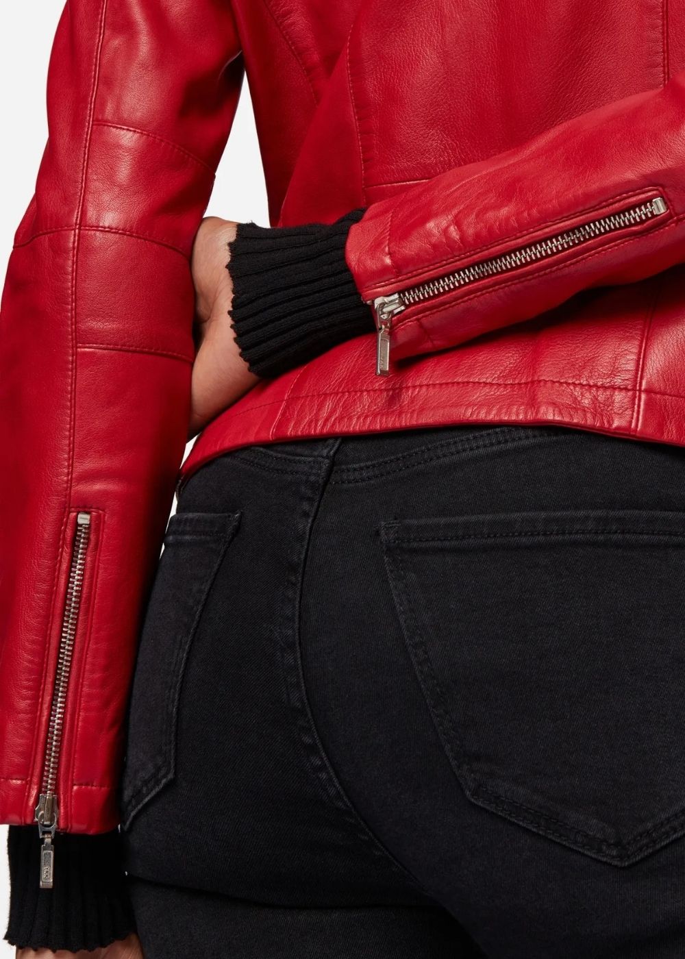 Veste en cuir rouge avec fermetures éclair portée par une femme, en mettant l'accent sur le design de la veste.