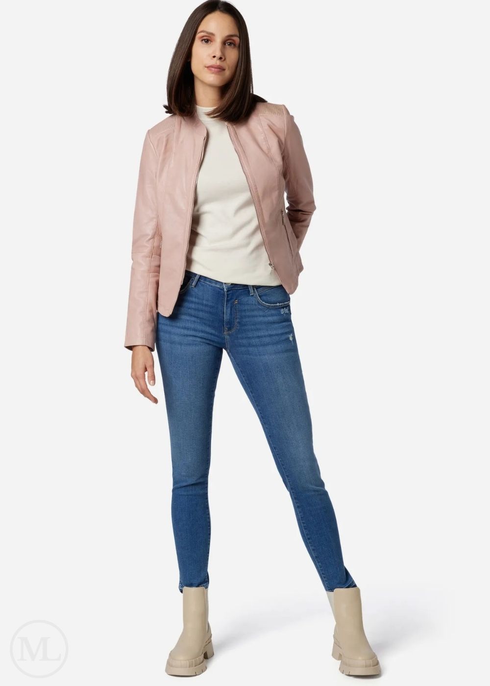 Woman wearing a rose gold jacket, white shirt, blue jeans, and beige boots on a white background