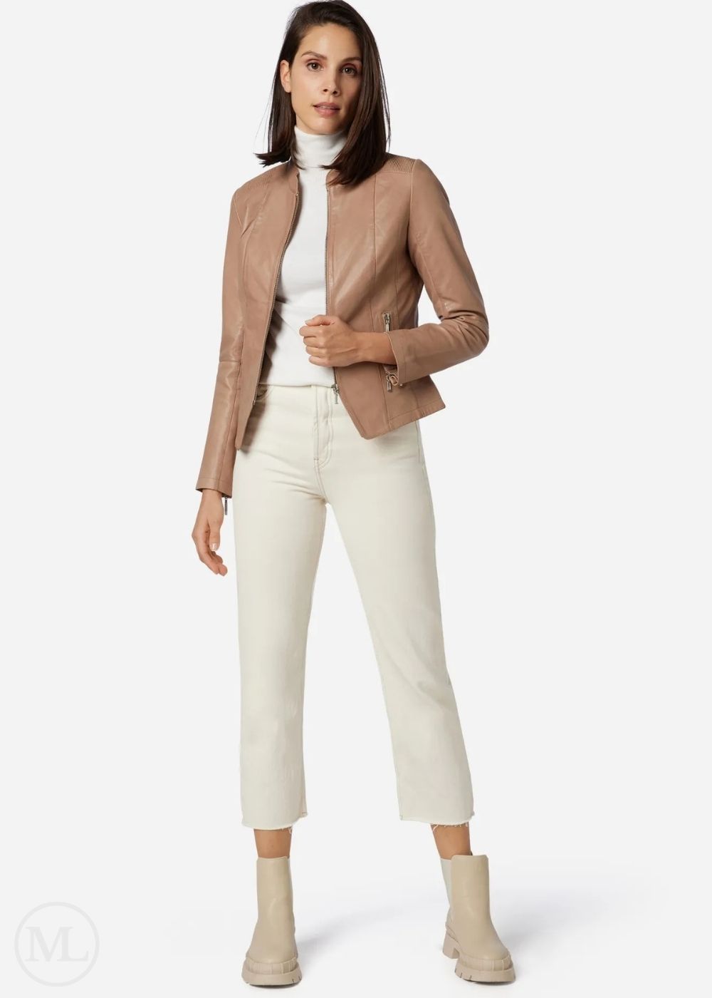 Woman wearing a taupe jacket, white turtleneck, and white pants on a white background