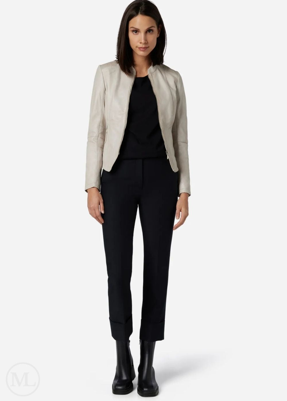 Woman wearing a White leather jacket, black top, and black pants on a white background