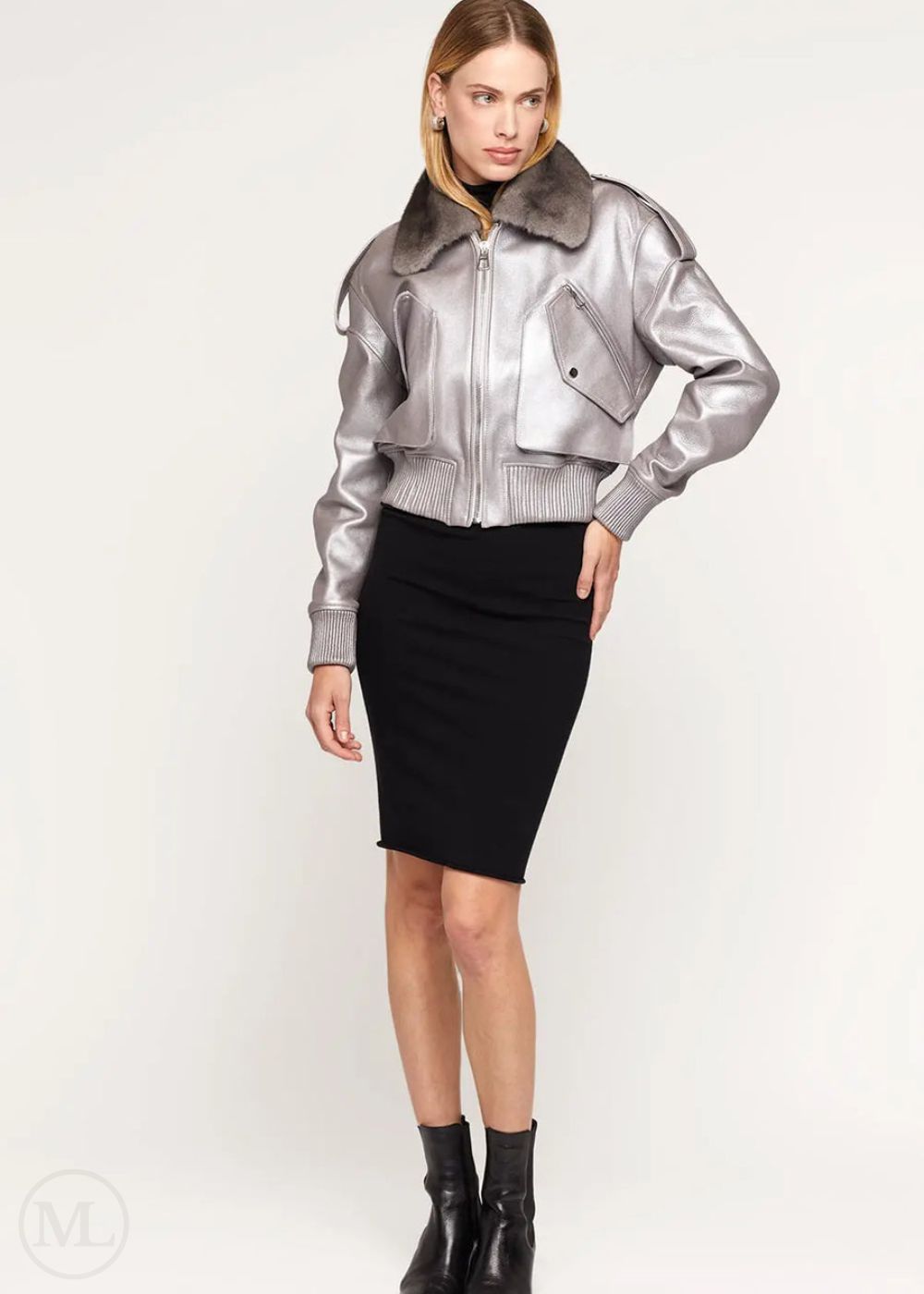 Woman wearing a silver leather bomber jacket on a white background