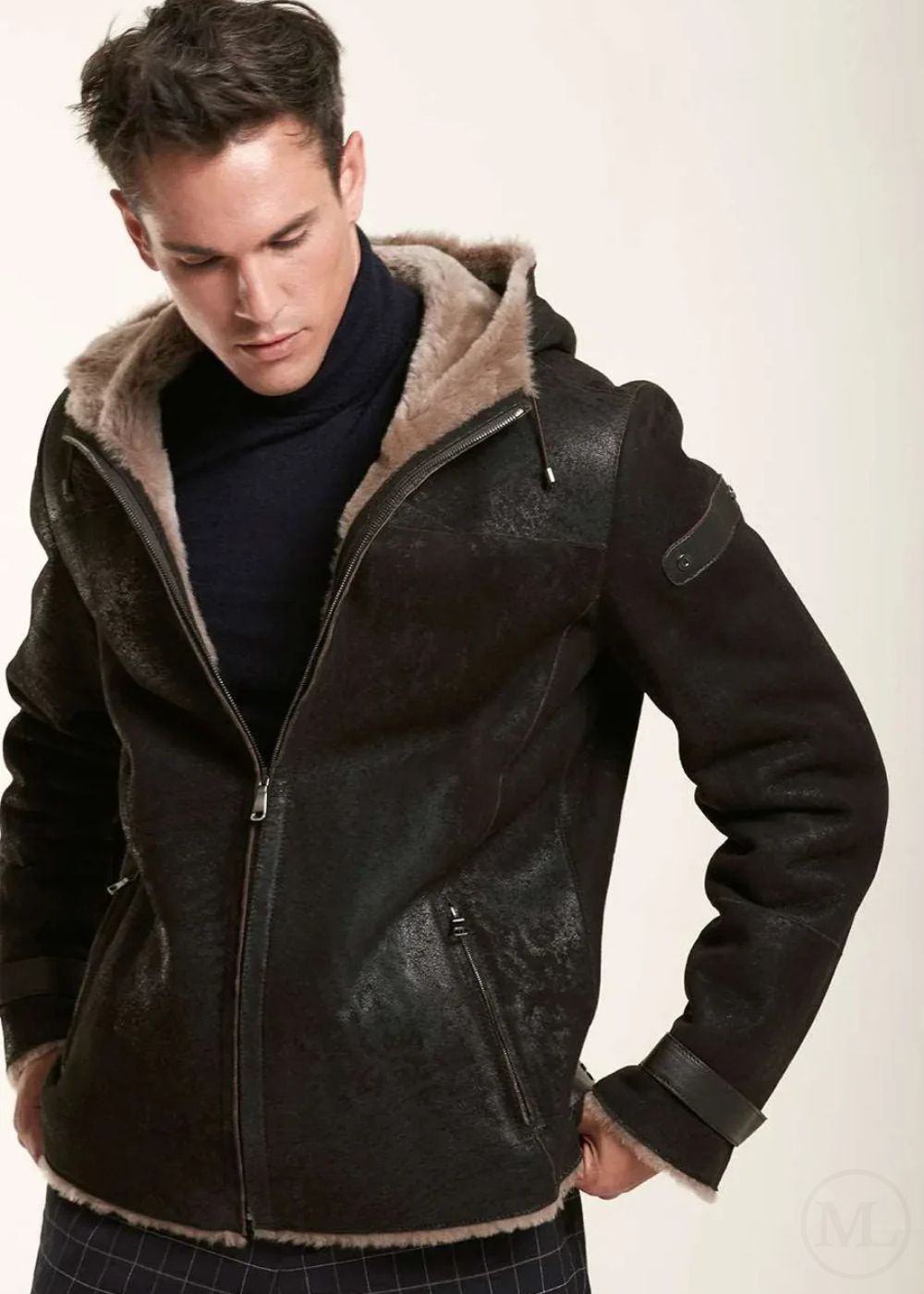 Man wearing a dark brown leather jacket with fur lining on a white background