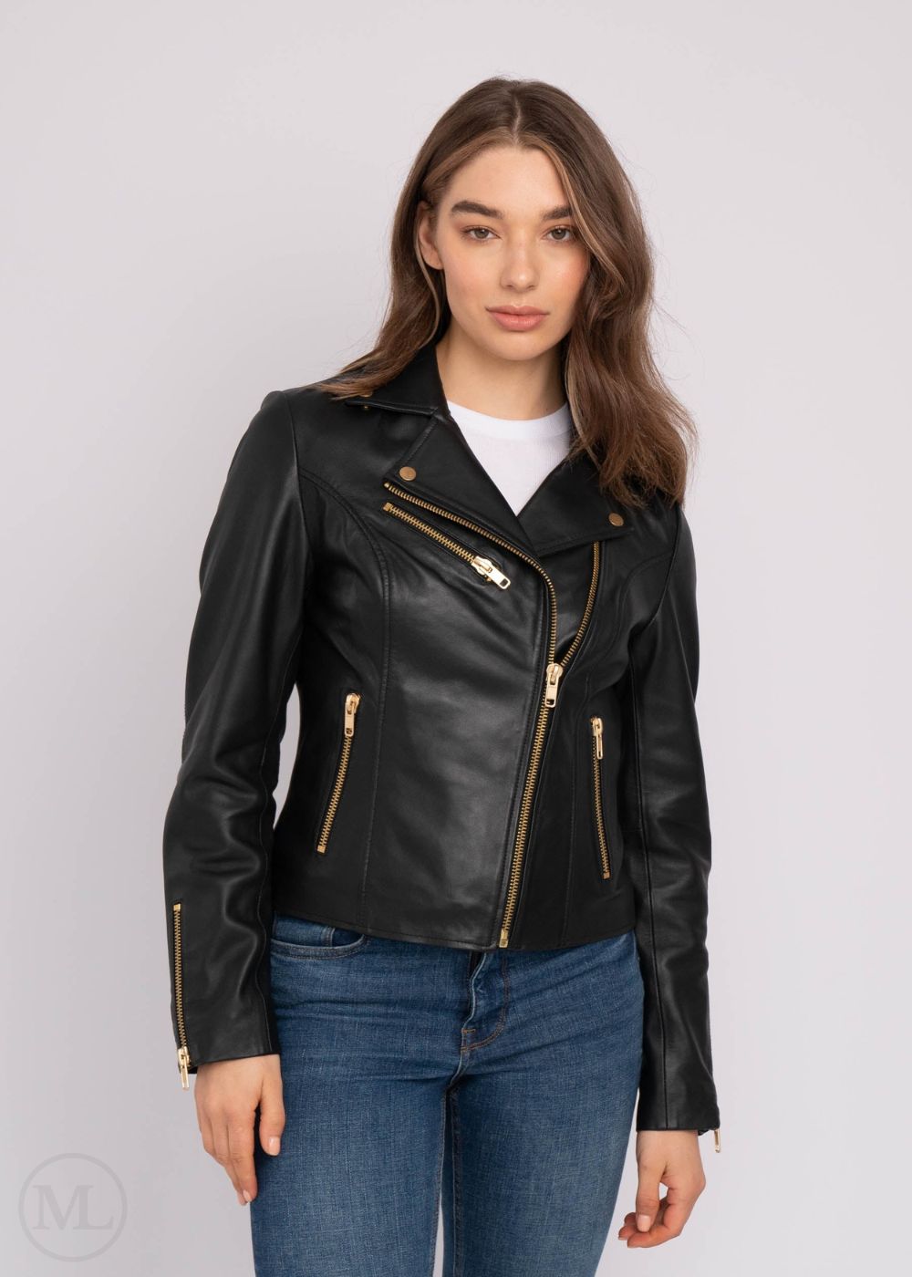 Woman wearing a black leather biker jacket with gold zippers on a white background