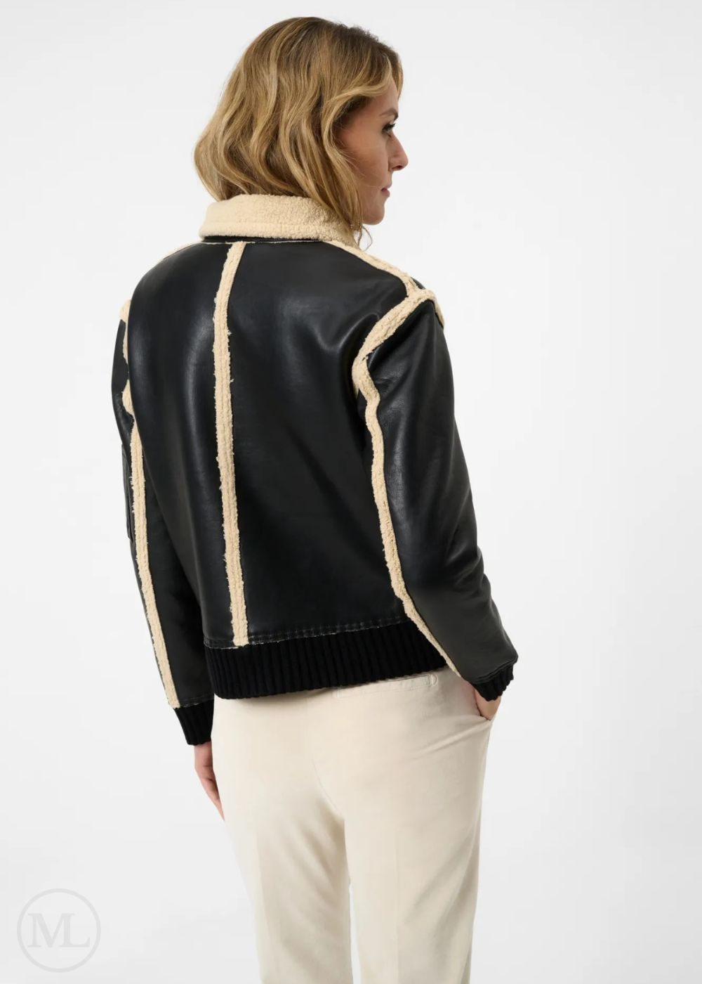 Women wearing a black leather jacket with beige trim on a white background