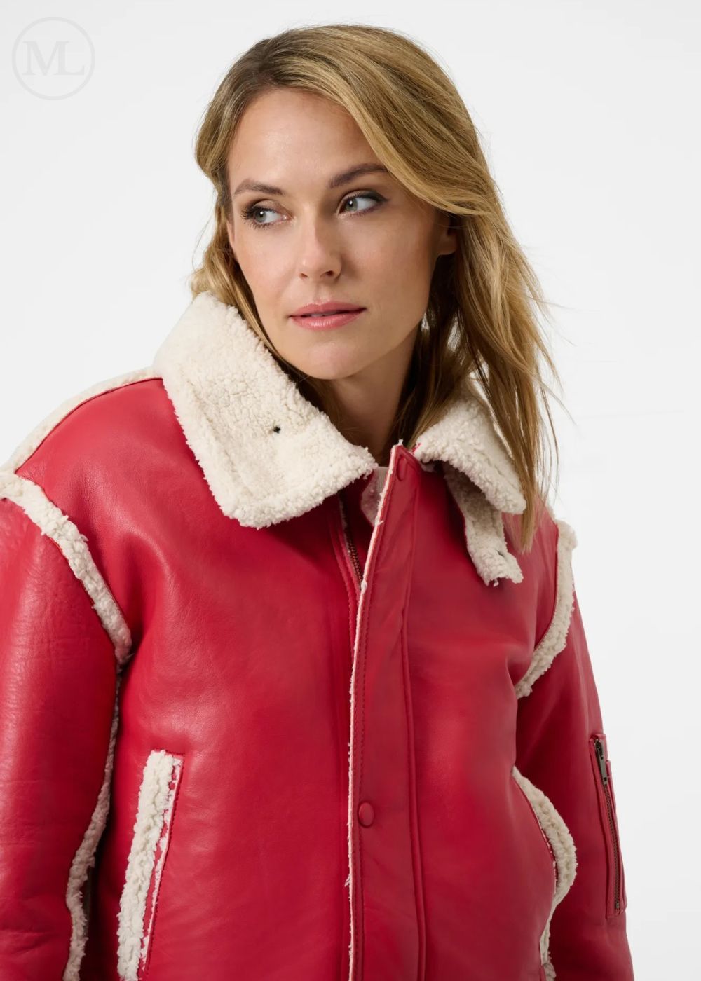 Woman wearing a red leather aviator jacket with white fur trim on a white background
