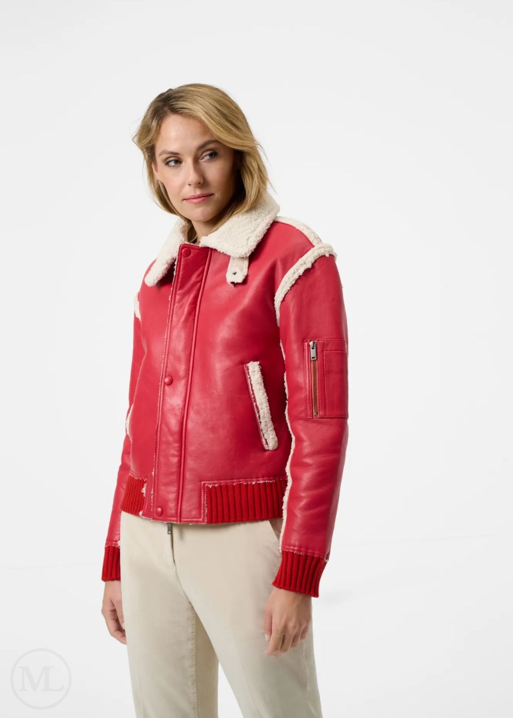 Woman wearing a red leather aviator jacket with white fur collar and cuffs on a white background