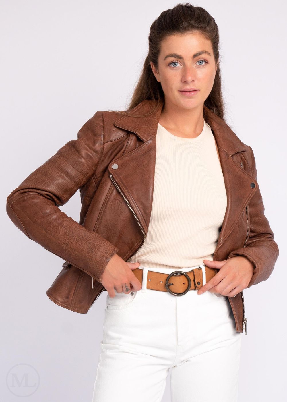 Femme portant une veste en cuir marron cognac sur fond blanc