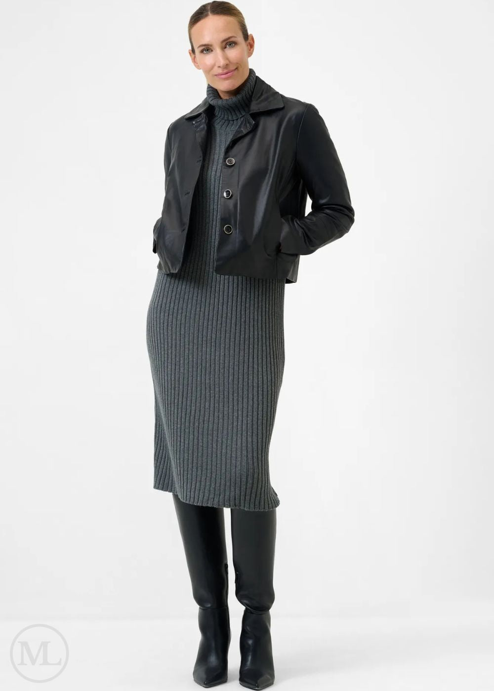 Woman wearing a black leather blazer jacket, black turtleneck, gray ribbed skirt, and black boots on a white background