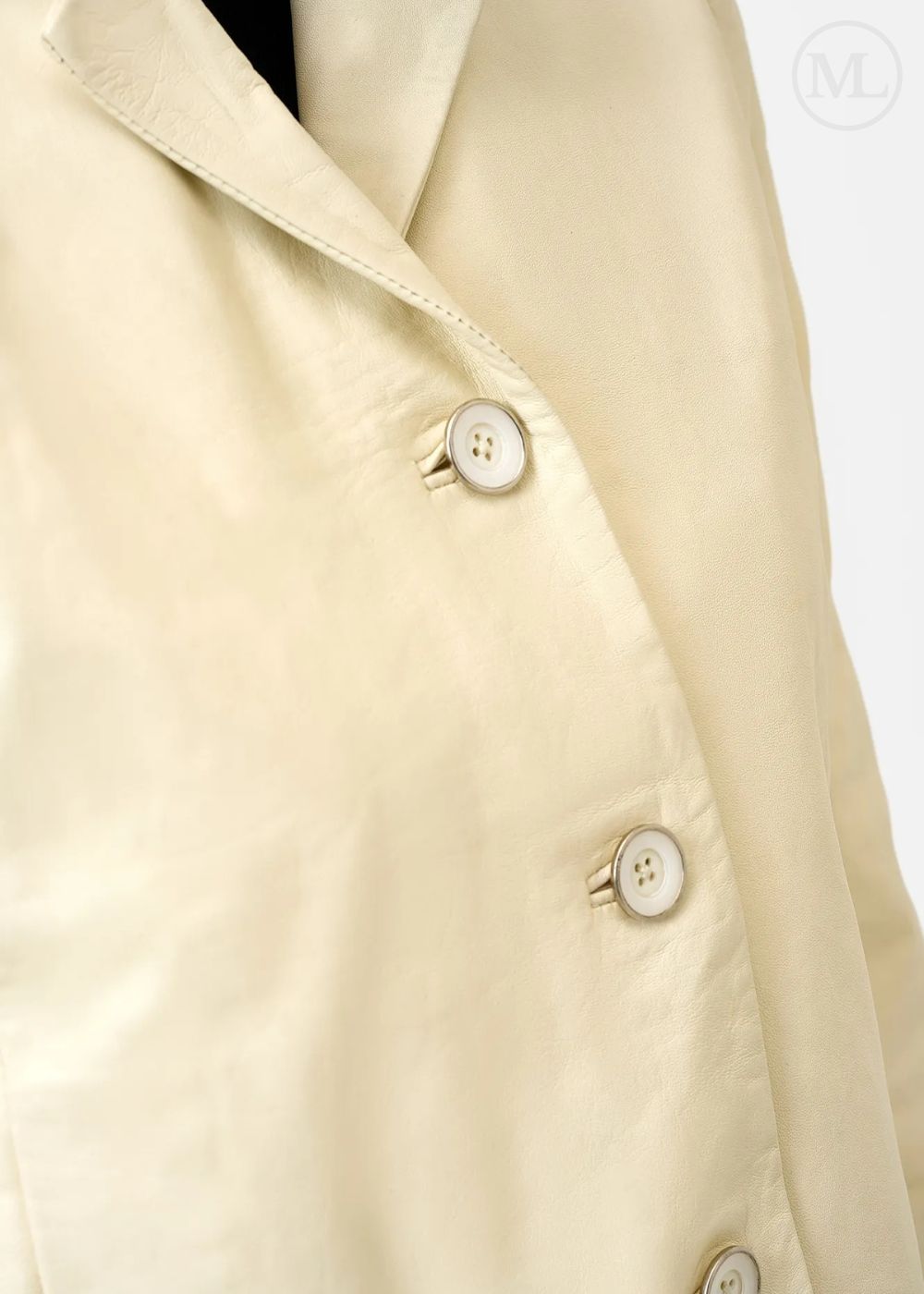 Gros plan d'une veste blazer en cuir ivoire avec boutons sur fond blanc