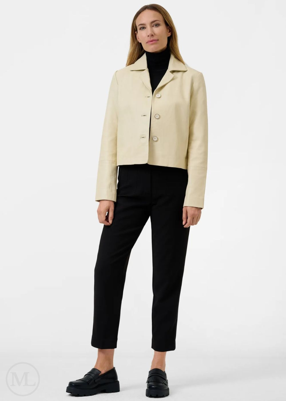 Woman wearing a lvory leather blazer jacket and black pants on a white background