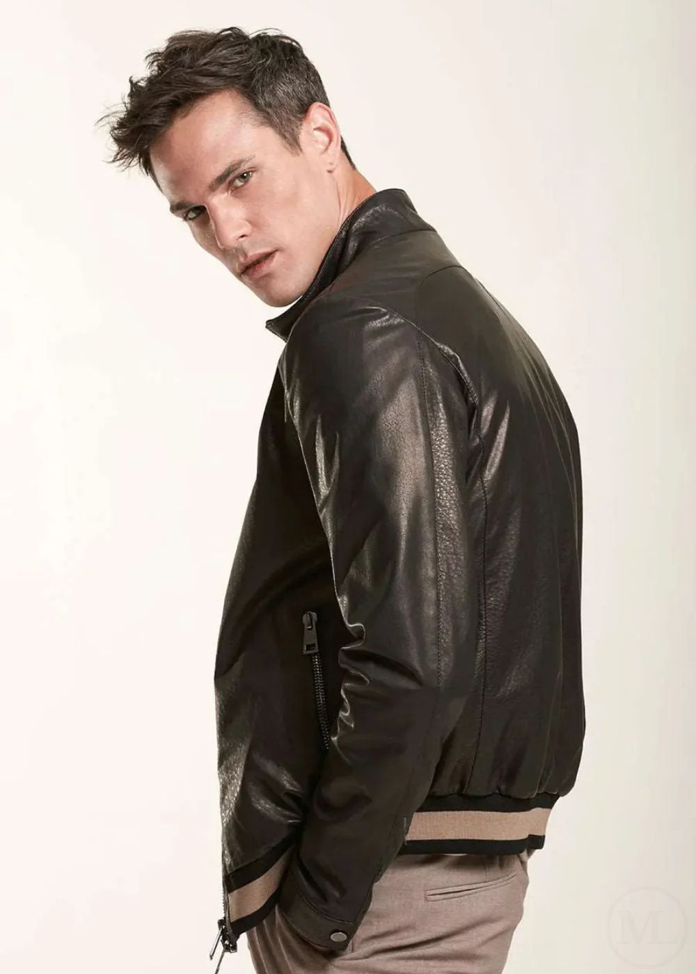 Man wearing a black leather bomber jacket on a white background