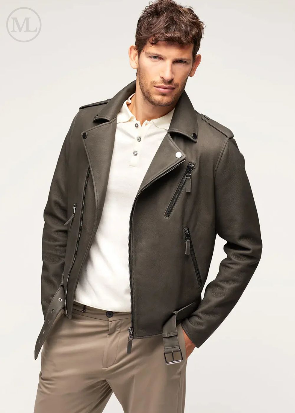 Man wearing a olive khaki leather biker jacket over a white shirt on a light gray background