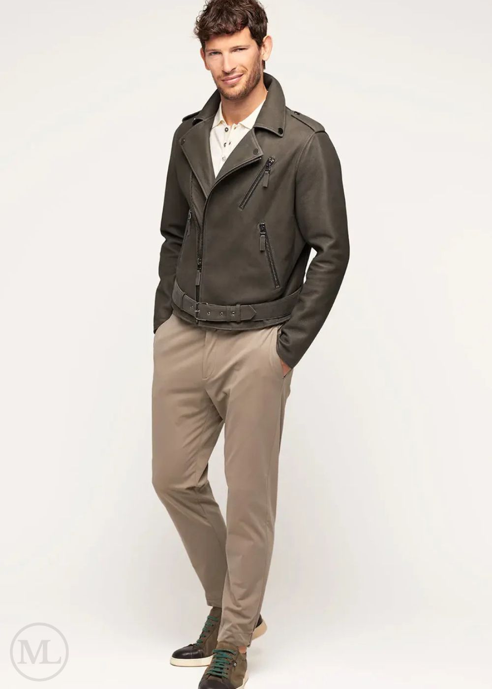 Man wearing a olive khaki leather biker jacket and beige pants on a white background