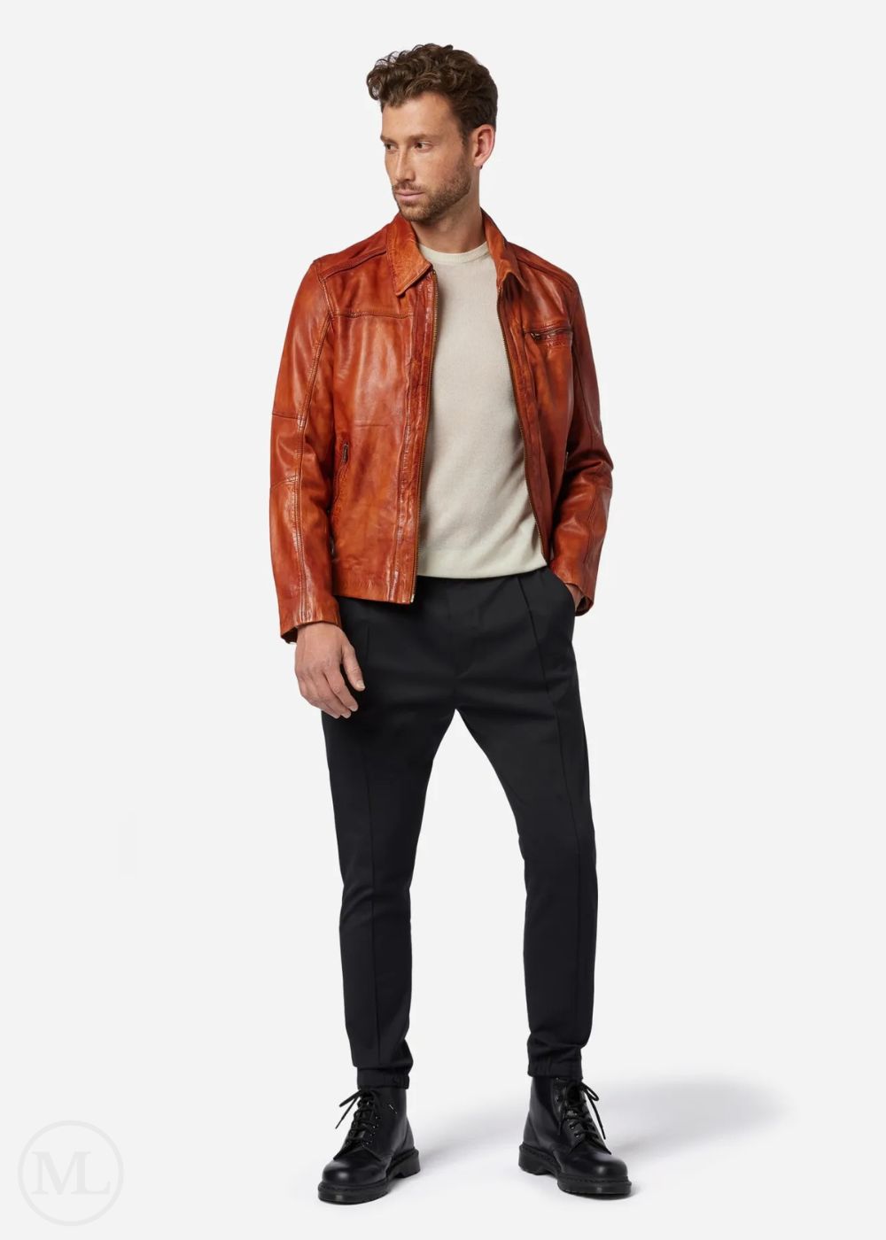 Man wearing a cognac brown leather jacket, white shirt, black pants, and black shoes on a white background