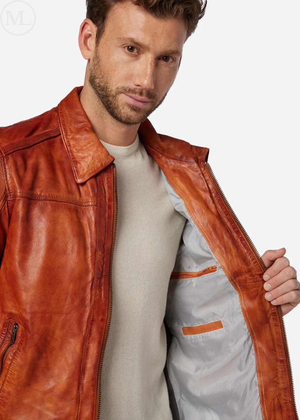 Man wearing a cognac brown leather jacket over a light gray shirt on a white background