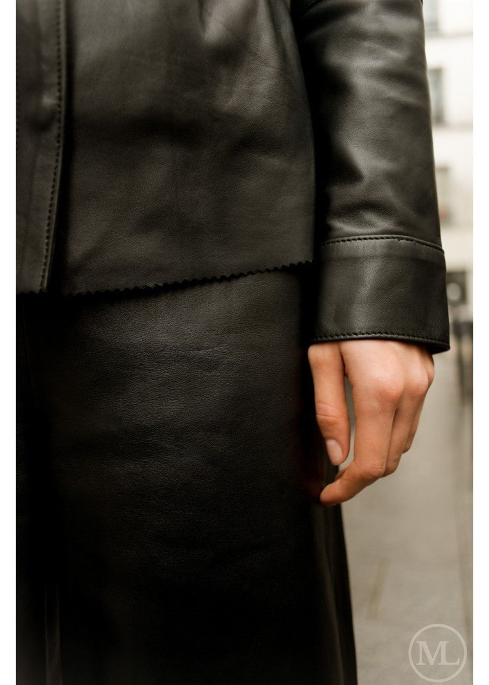 Close-up of a woman wearing a black leather shirt with a blurred background