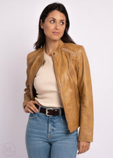 Woman wearing a Camel leather biker jacket, white shirt, and blue jeans on a white background