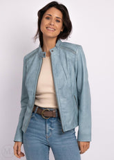 Woman wearing a ice blue leather biker jacket and jeans on a white background