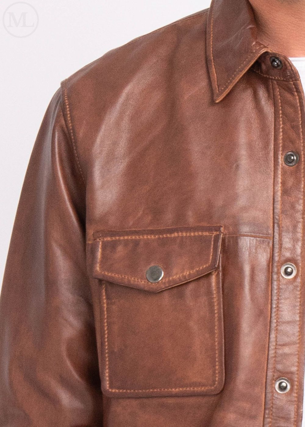 Close-up of a cognac brown leather jacket with a pocket worn by a man on a white background