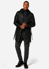 Man wearing a black leather coat and pants on a white background