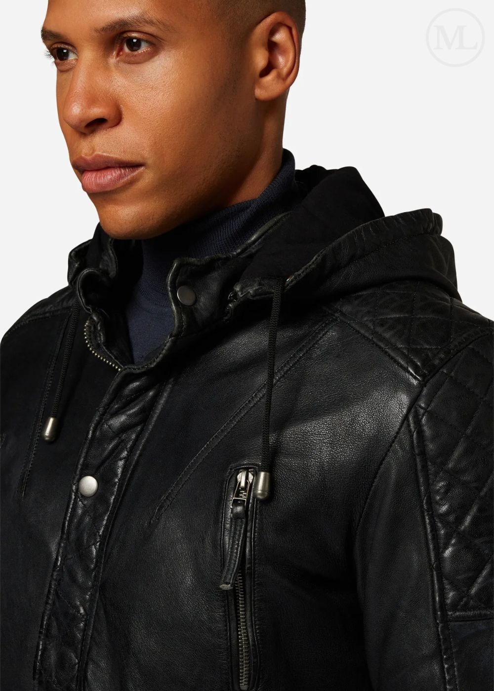 Man wearing a black leather coat with a hood on a plain background