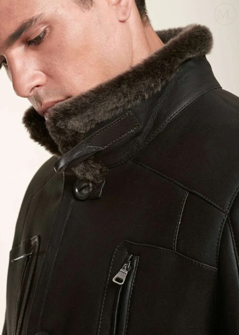 Close-up of a dark brown coat with fur collar on a neutral background