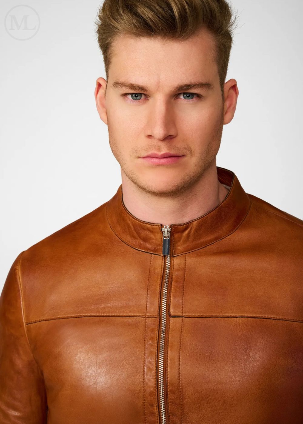 Man wearing a brown leather biker jacket against a plain background