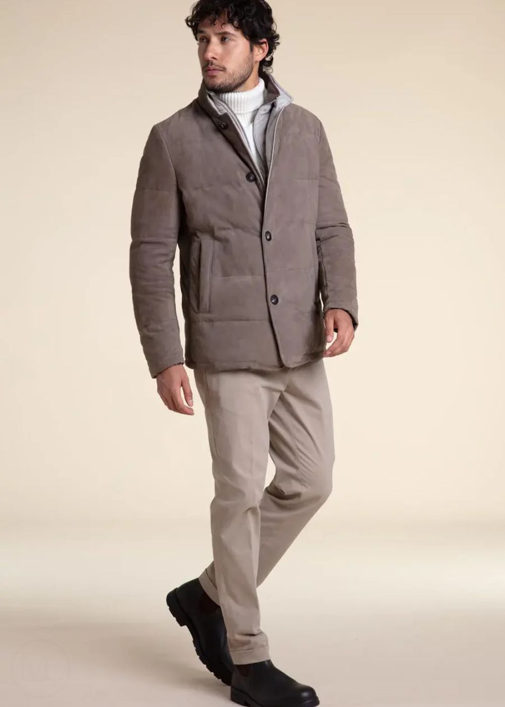 Man wearing a camel suede leather jacket and beige pants on a beige background
