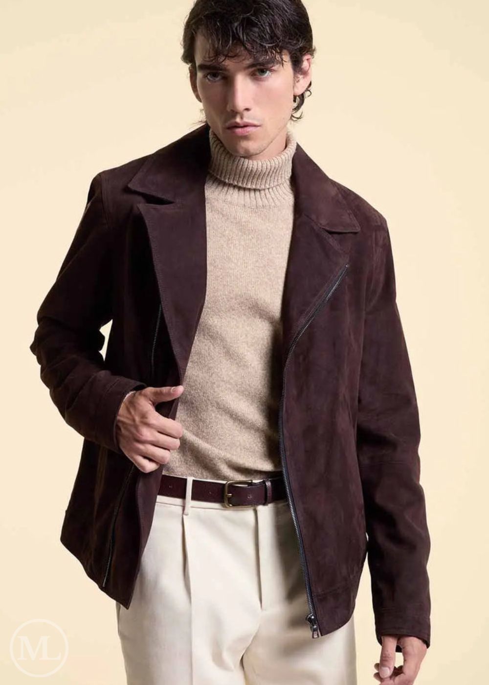 Man wearing a dark brown suede jacket over a beige sweater and pants on a beige background
