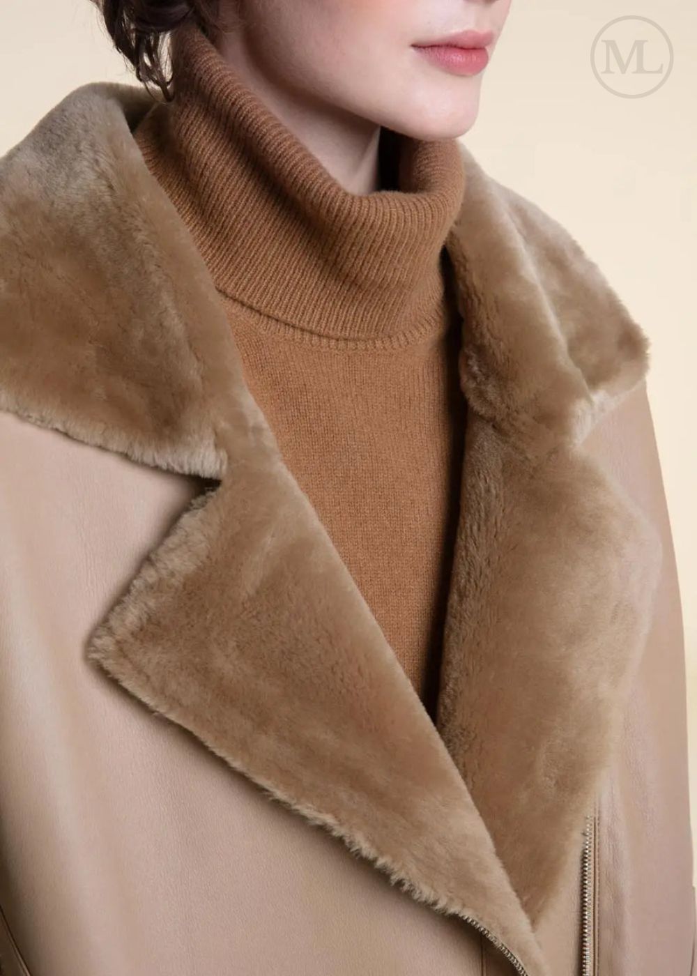 Close-up of a person wearing a shearling leather coat with fur collar and a brown turtleneck sweater.