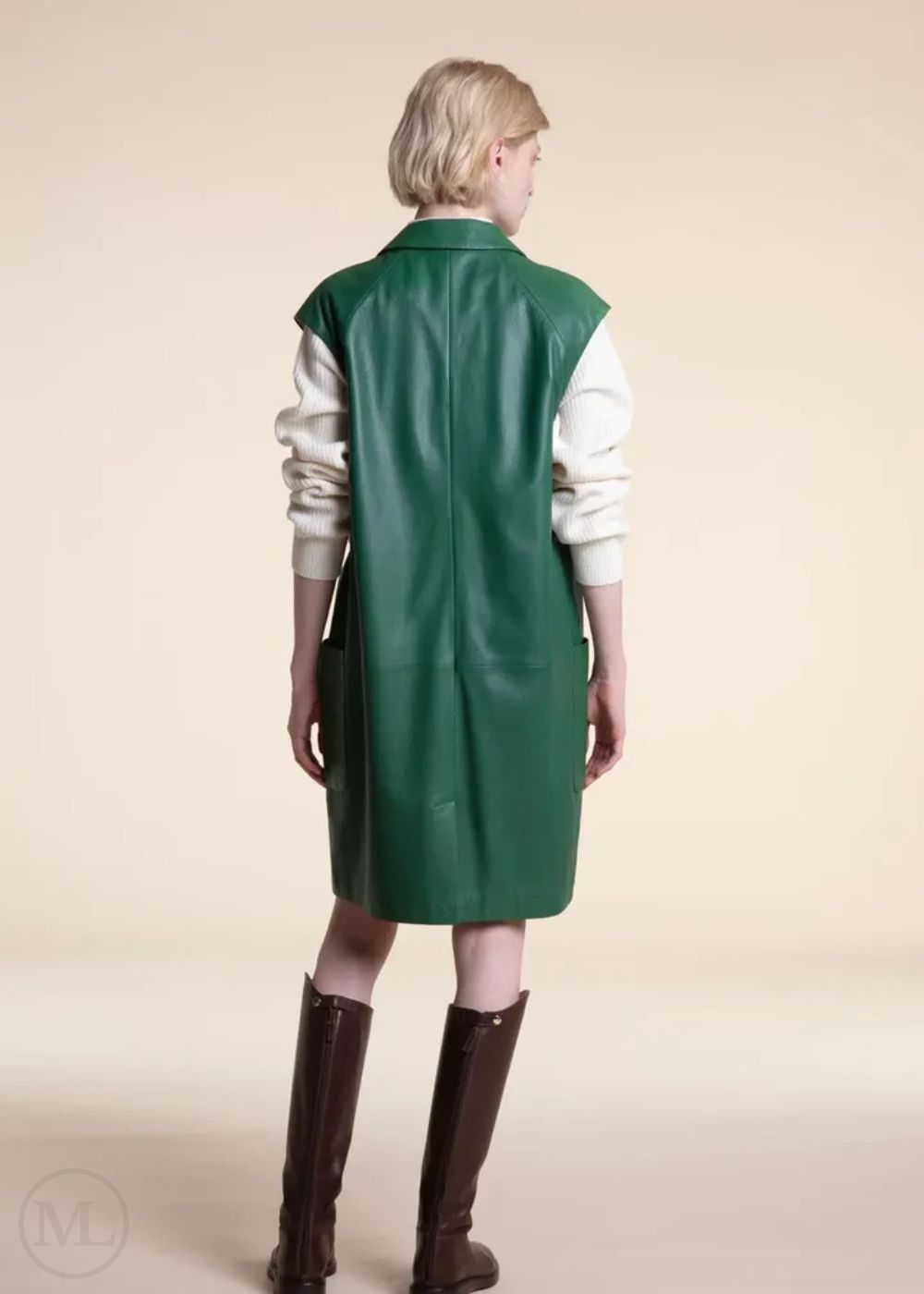 Women wearing a Emerald green leather coat apron over a white shirt on a beige background