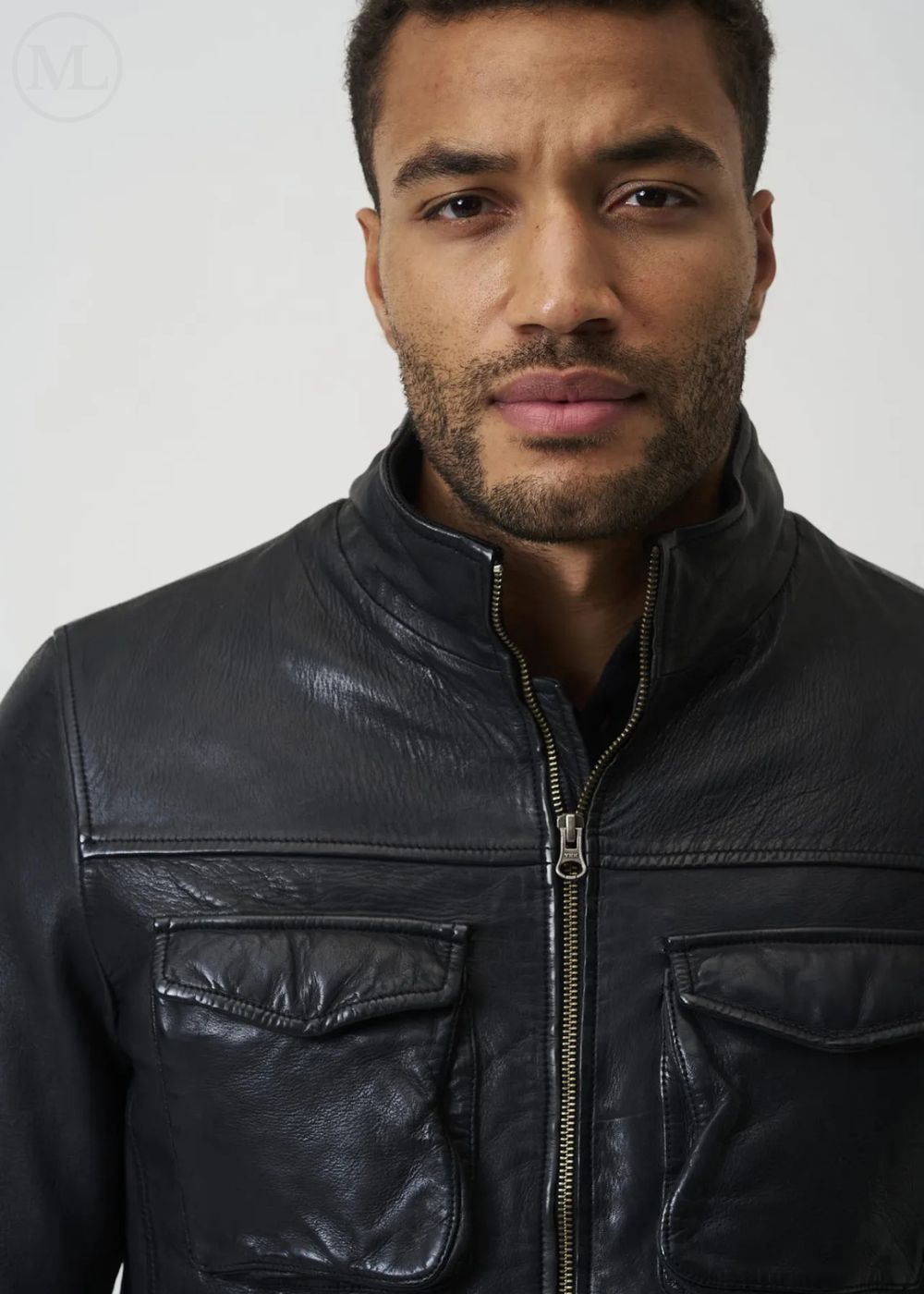 Man wearing a black leather jacket against a plain background