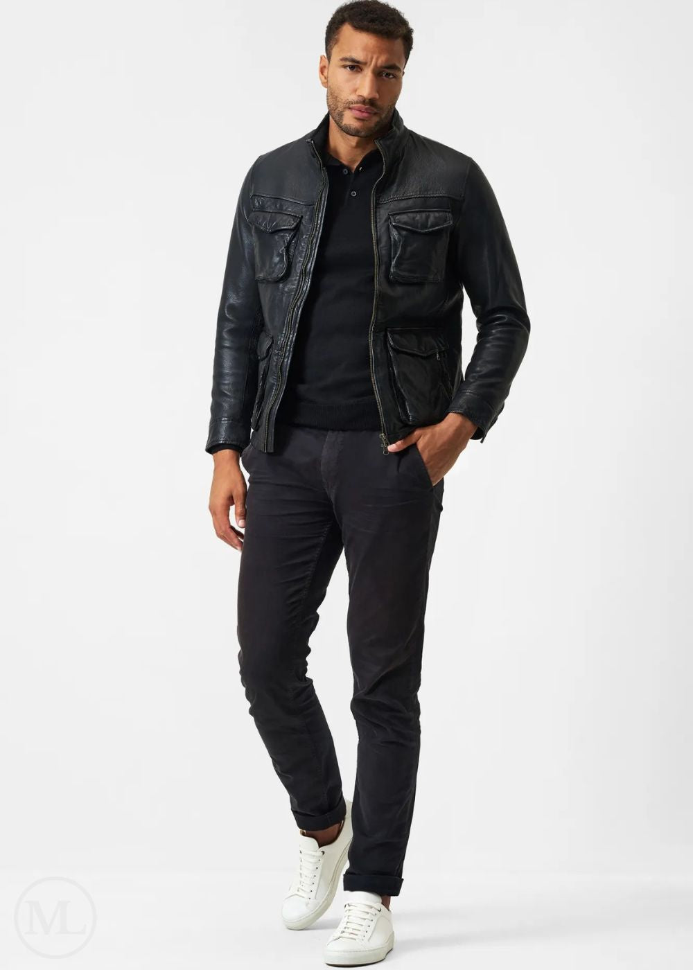 Man wearing a black leather jacket, black shirt, black pants, and white sneakers on a white background