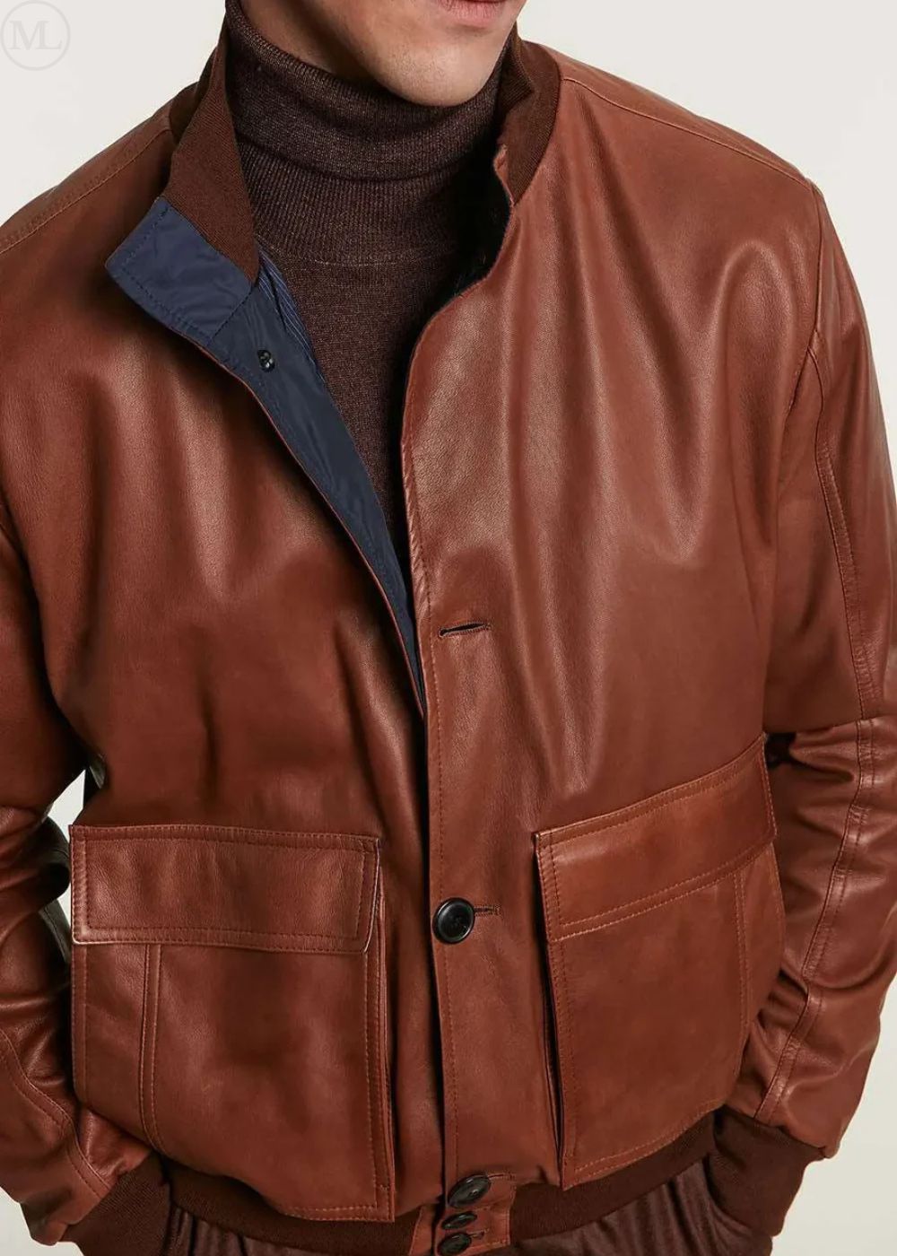 camel leather bomber jacket with front flap pockets worn by a man on a plain background