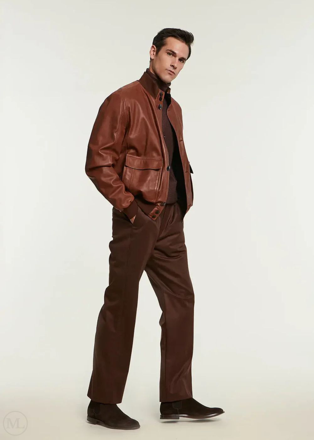 Man wearing a cognac leather jacket and pants on a white background
