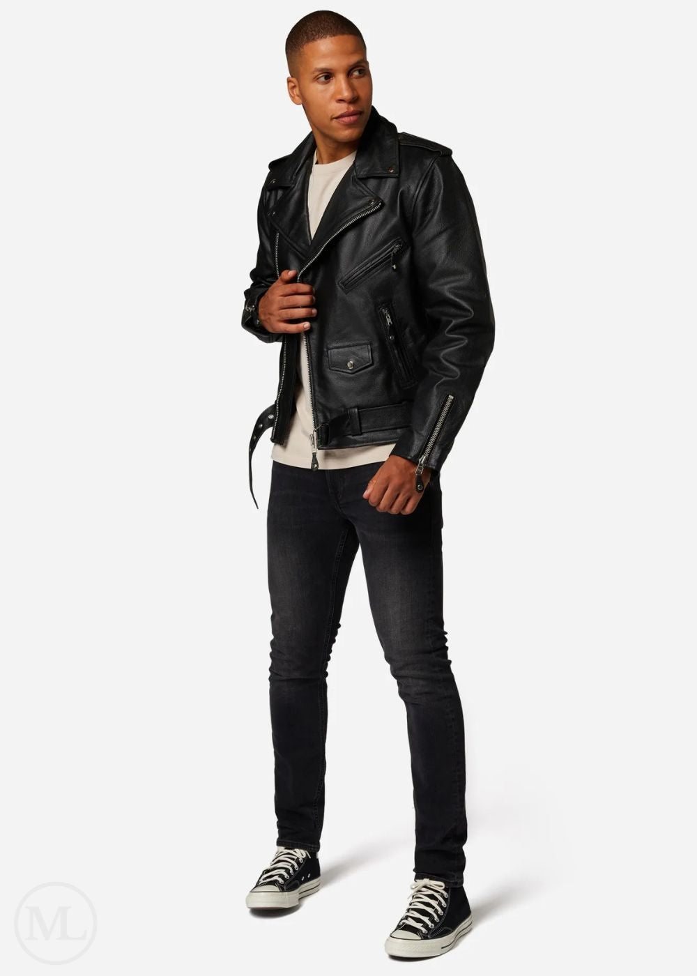 Man wearing a black leather biker jacket and black pants on a white background