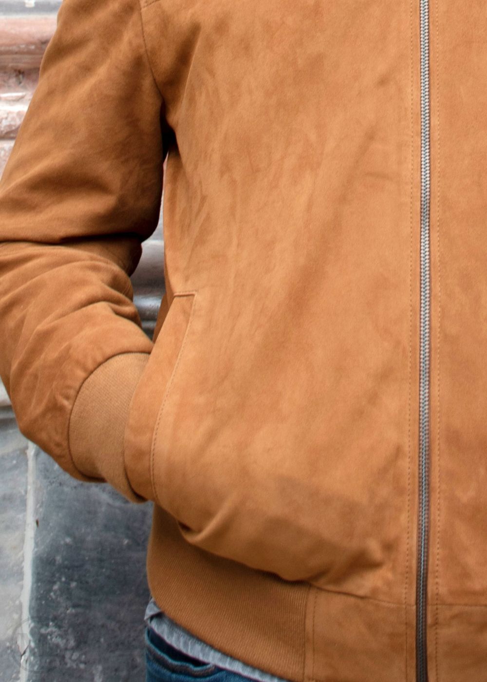 Close-up of a cognac brown suede jacket with a blurred background