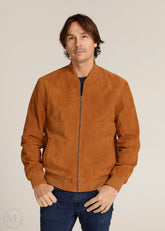 Man wearing a cognac brown suede jacket against a beige background