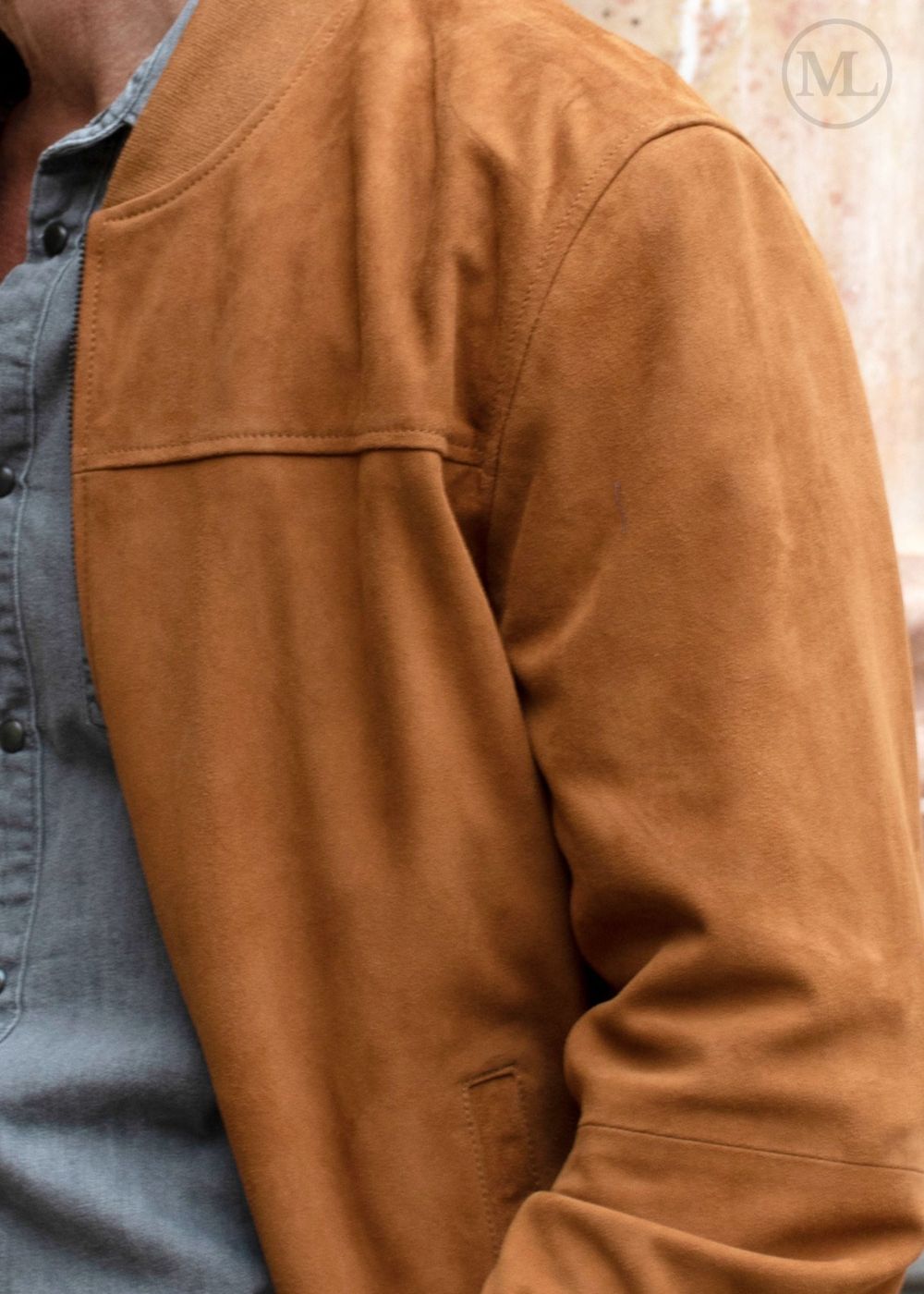 Close-up of a cognac brown suede jacket with a blurred background