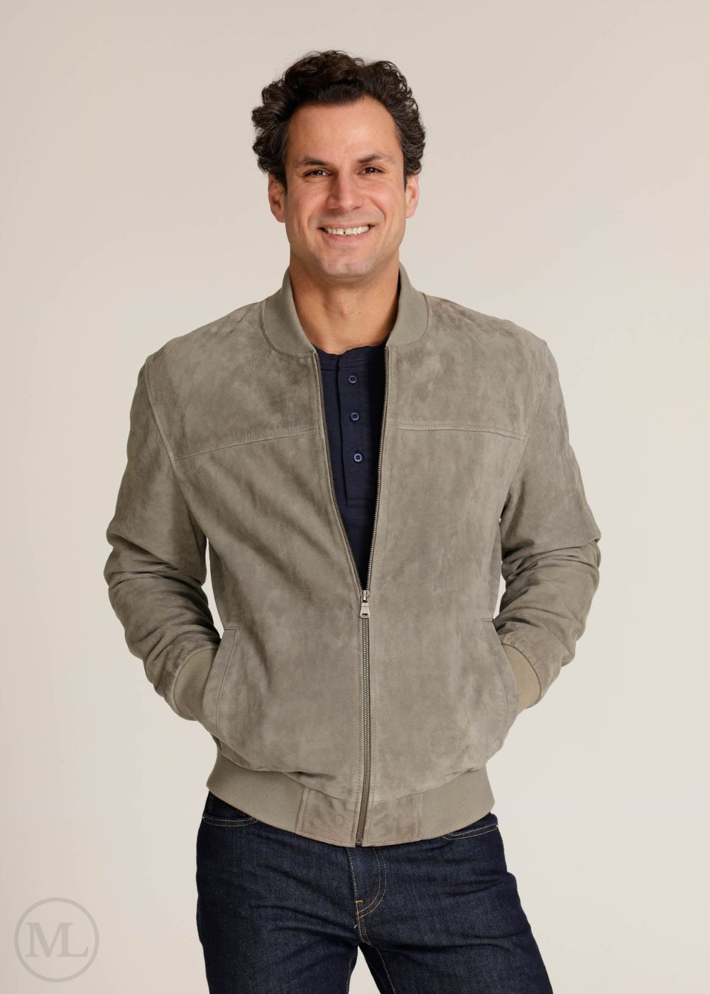 Man wearing a light grey suede jacket on a beige background